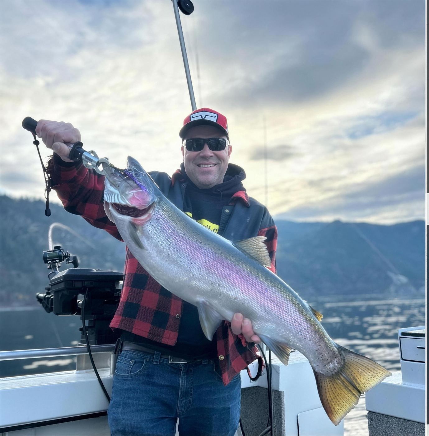 Angler with a rainbow trout on a Kalamalka Lake fishing charter
