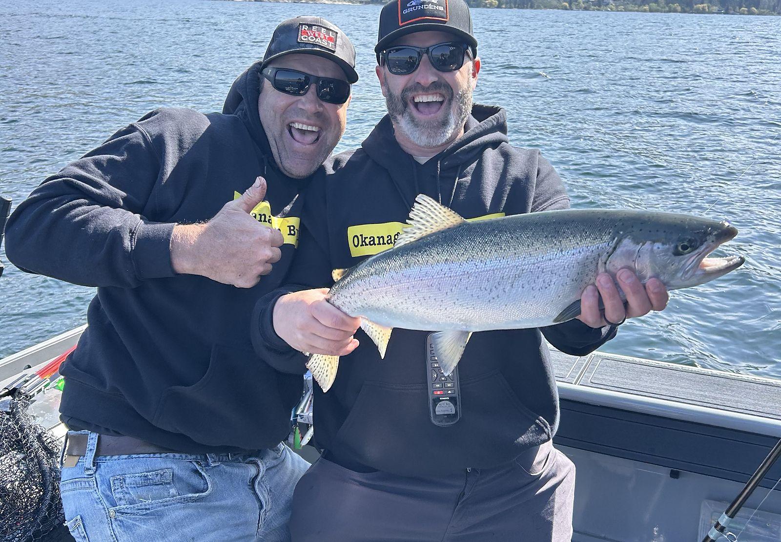 Two anglers with a rainbow trout on an Okanagan Lake charter